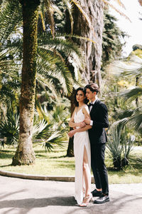 A beautiful couple in love, bride and groom in wedding clothes, walk and pose in the park in nature