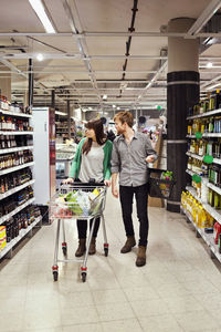 Young couple walking while shopping in supermarket