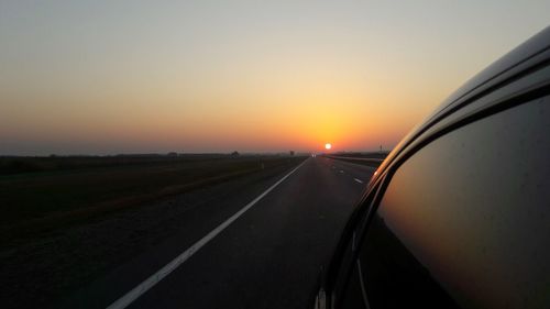 Car on road against sky during sunset