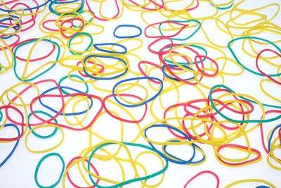 High angle view of colorful rubber bands on white background