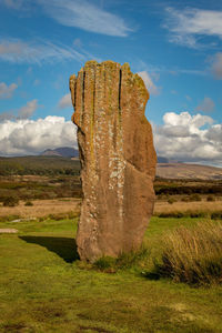 Stone wall on field against sky