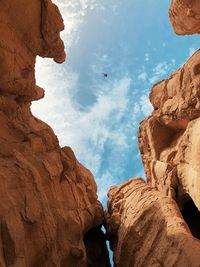 Low angle view of rock formations against cloudy sky