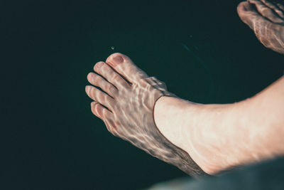 Low section of woman feet in water at lake