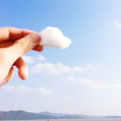 Cropped image of person holding hands against clear sky