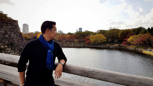 Man looking over lake against sky