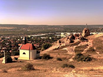 Aerial view of chapel on a hill with city in the background against sky