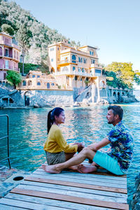 Couple sitting on built structure