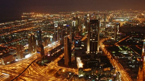 High angle view of illuminated street amidst buildings at night