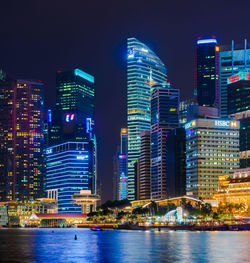 Illuminated buildings in city against sky at night