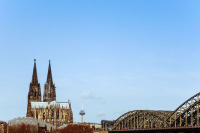 Cologne cathedral and hohenzollern bridge against clear sky in city