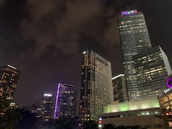 Low angle view of illuminated buildings against sky at night