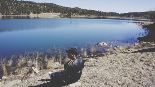 Man sitting by lake