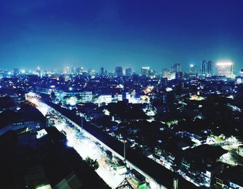 High angle view of illuminated city buildings against clear sky