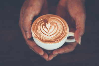 Cropped image of hand holding coffee cup