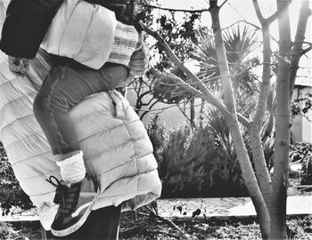 Rear view of couple sitting on tree