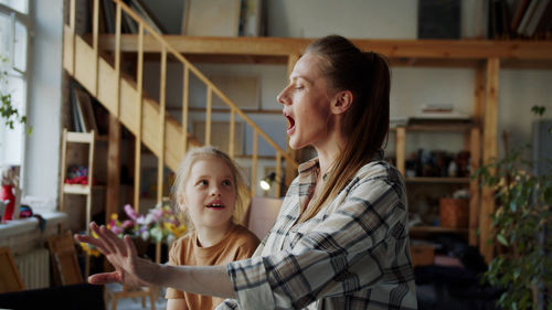 Mother and daughter laughing at home