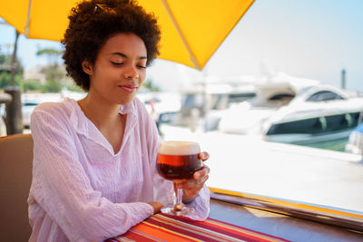 Portrait of young woman using mobile phone at restaurant