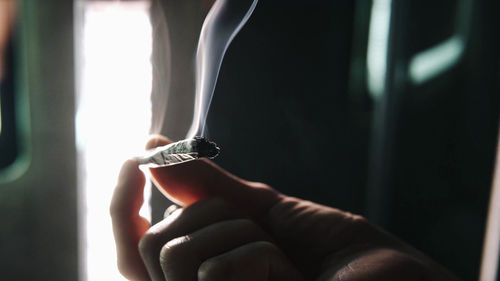 Close-up of hand holding cigarette