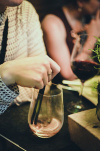 Midsection of person holding beer glass on table