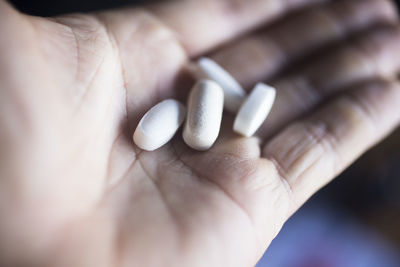 Close-up of person showing white pills