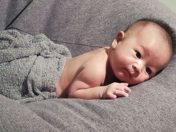 Portrait of cute baby lying on bed