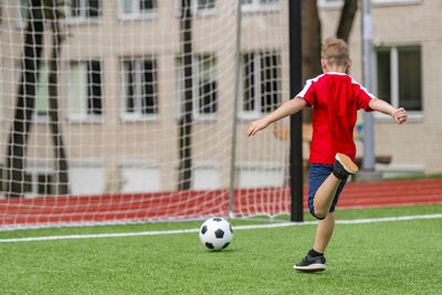 Full length of boy playing with soccer ball