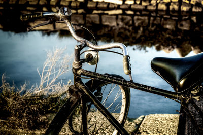 Close-up of bicycle parked by canal