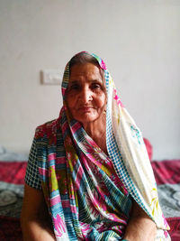 Portrait of smiling senior woman on bed at home