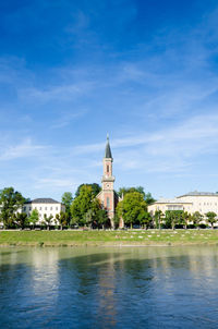 Building by trees against blue sky