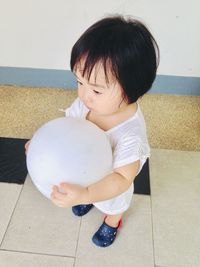 Cute boy holding balloons on floor
