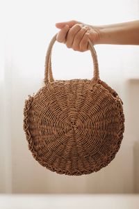 Close-up of hand holding wicker basket