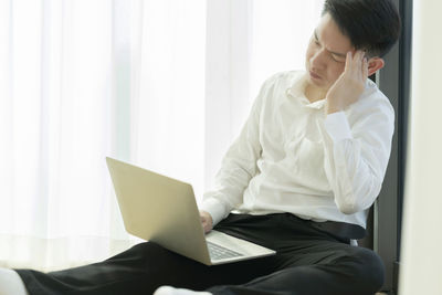 Midsection of man using mobile phone