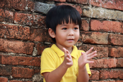 Portrait of boy against brick wall