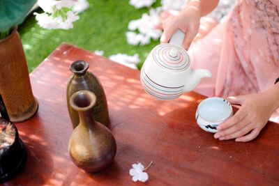 High angle view of hands holding coffee cup on table