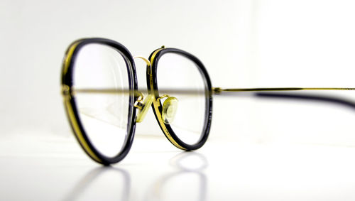 Close-up of eyeglasses on table against white background