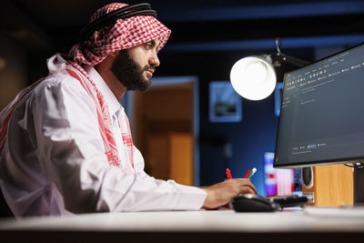 Side view of man using laptop at clinic