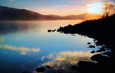 Scenic view of lake against sky during sunset