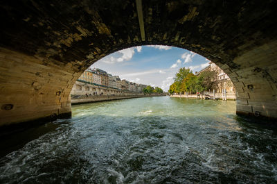 Arch bridge over river against sky