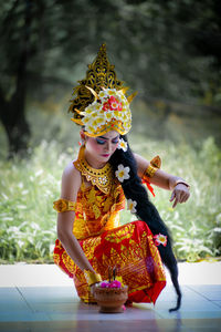 Portrait of young woman wearing traditional clothing while sitting on street