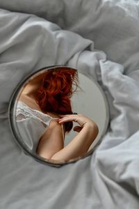 High angle view of woman reflected on mirror