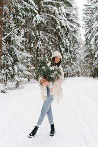 Full length of woman standing on snow covered field