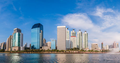 Sea by buildings against sky in city