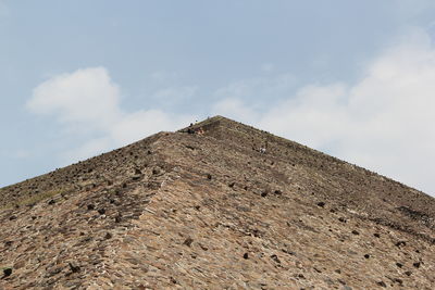 Low angle view of rock on mountain against sky