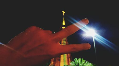 Close-up of hand holding illuminated lighting equipment