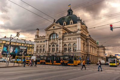People walking on street against buildings in city