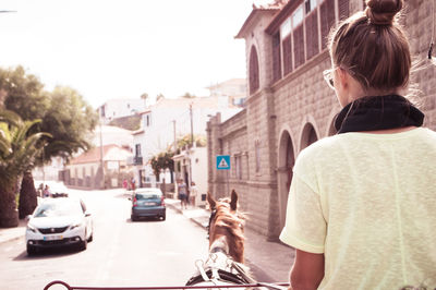 Rear view of woman on street in city