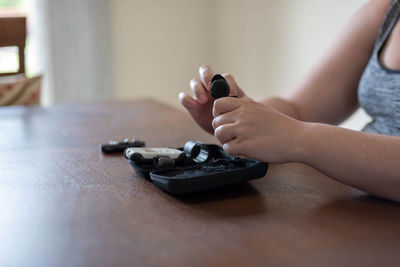 Close-up of woman holding hands on table at home