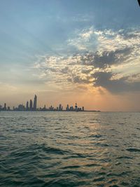 Scenic view of sea and buildings against sky during sunset