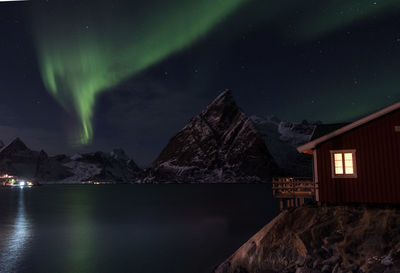 Aurora polaris over lake against sky at night