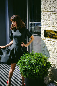 Young woman standing against wall